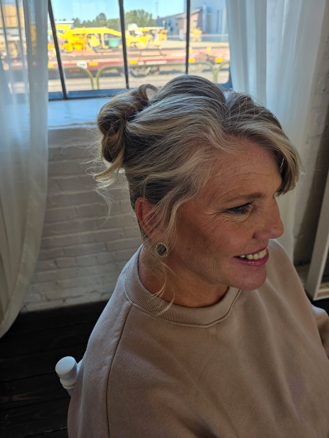 Smiling client in profile with a soft textured updo