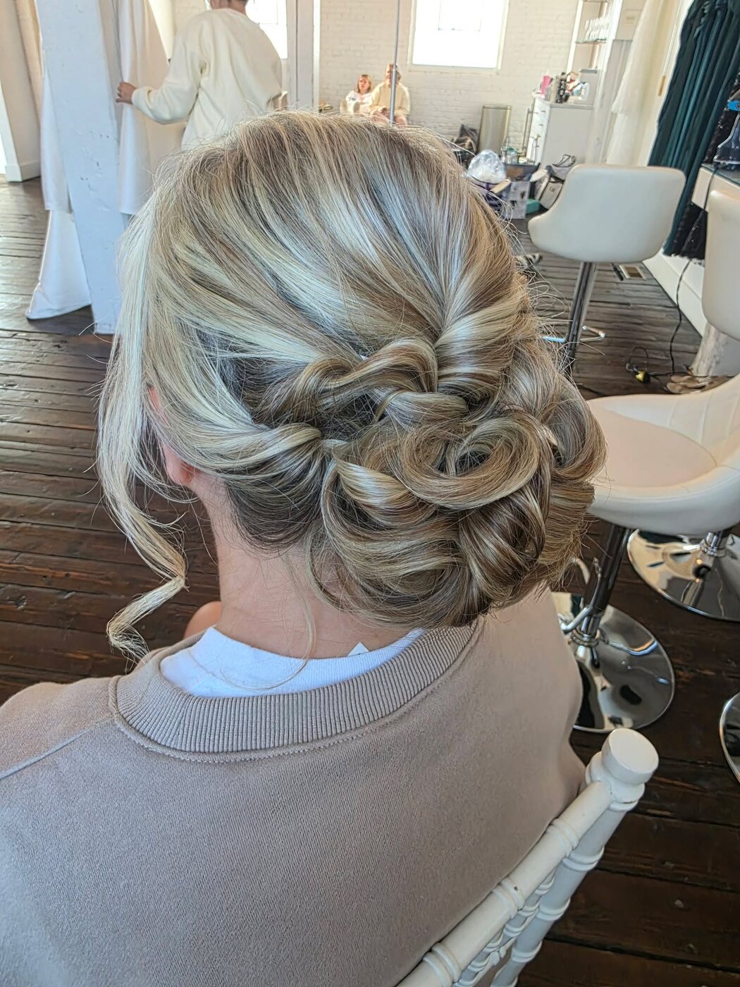 Bride seated in the salon with a soft textured updo