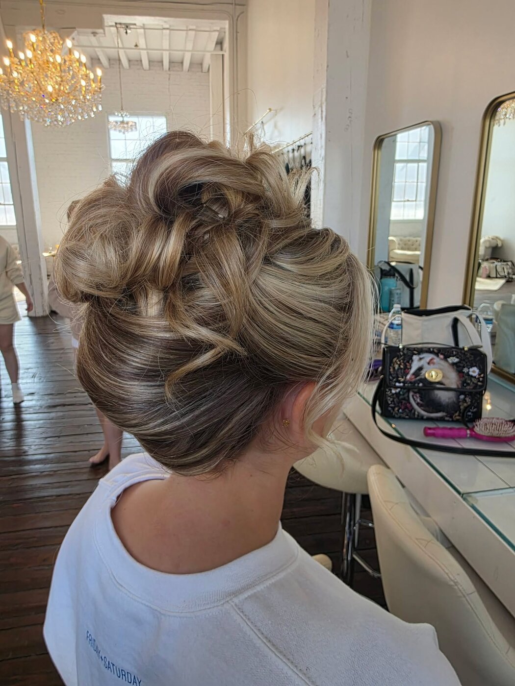Bride at the styling chair with a sculpted high bun